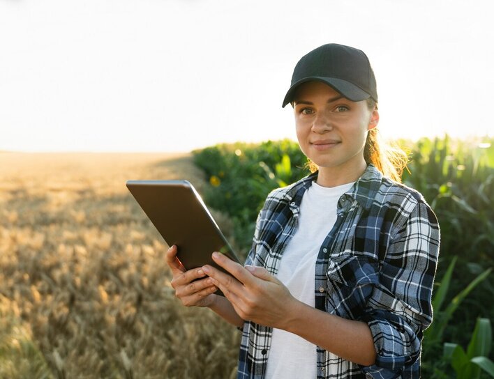 Digitale Datenerfassung in der Landwirtschaft Frau mit Tablet auf einem Feld bei Sonnenlicht.