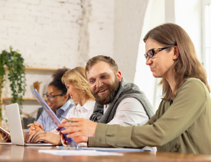 Gruppe arbeitet gemeinsam mit Laptops im Seminarraum Personen bei gemeinsamer Gruppenarbeit mit Laptops