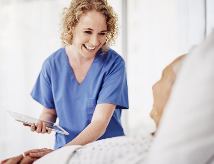 Pflegekraft im Gespräch mit Patientin Digitale Unterstützung in der empathischen Pflegearbeit