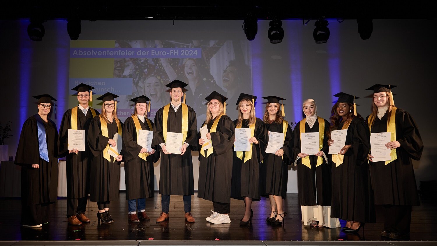 Gruppe Absolvent/innen auf der Bühne bei der Absolventenfeier Mai 2024 im Hamburg